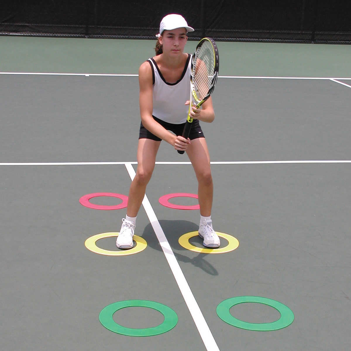 tennis play working on footing agility on tennis court with ring markers set